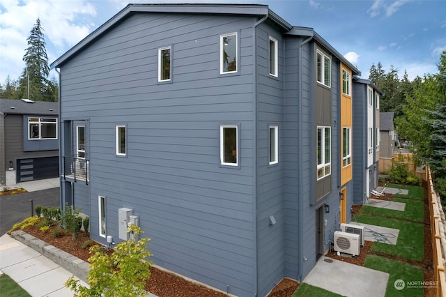 view of side of property with a garage and ac unit