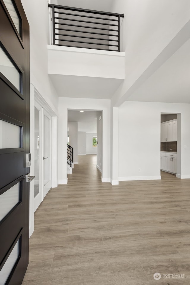 entryway with light wood-type flooring and a high ceiling