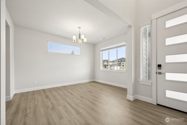 foyer entrance featuring an inviting chandelier and light hardwood / wood-style floors