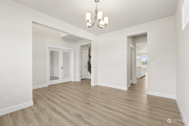 unfurnished dining area featuring a chandelier and light hardwood / wood-style flooring