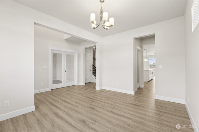 unfurnished dining area with a chandelier and light wood-type flooring