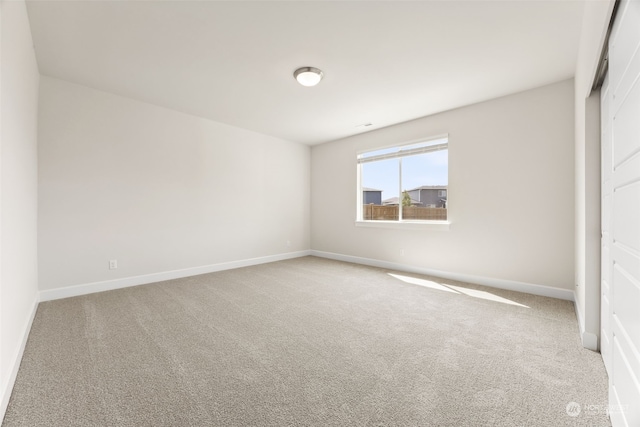 unfurnished bedroom with light colored carpet and a closet