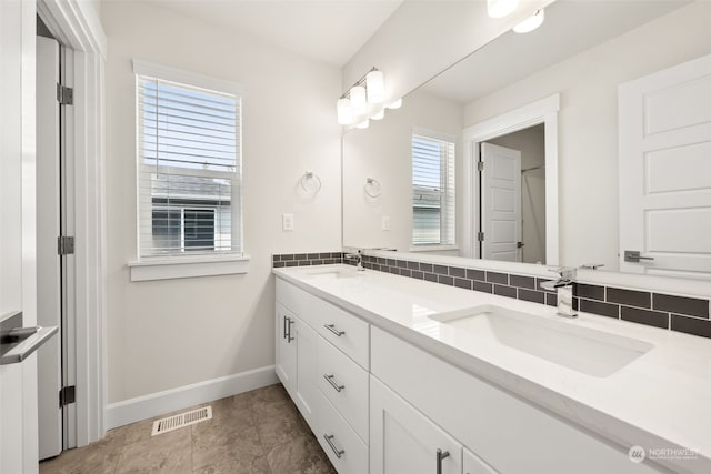 bathroom with tasteful backsplash and vanity