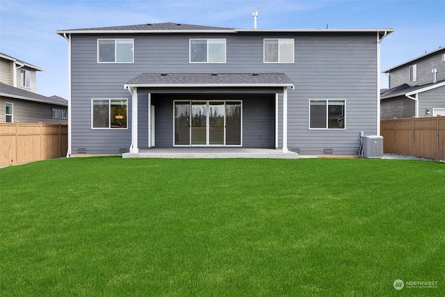 rear view of property with a yard, central AC unit, and a patio area