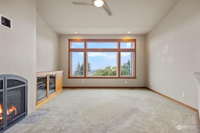 unfurnished living room with light carpet and ceiling fan