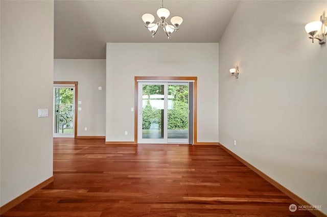 interior space featuring an inviting chandelier, a wealth of natural light, and dark wood-type flooring