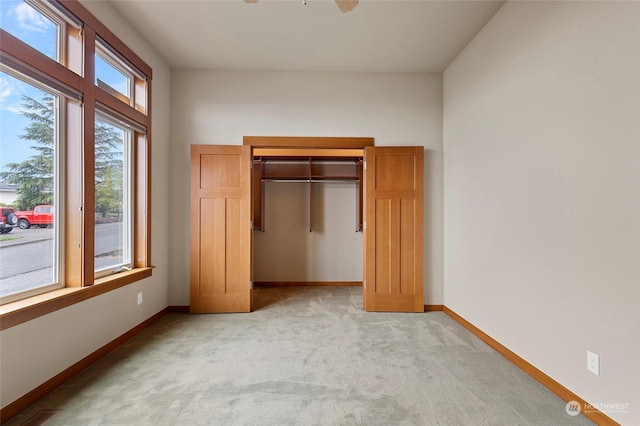 unfurnished bedroom featuring ceiling fan and light carpet