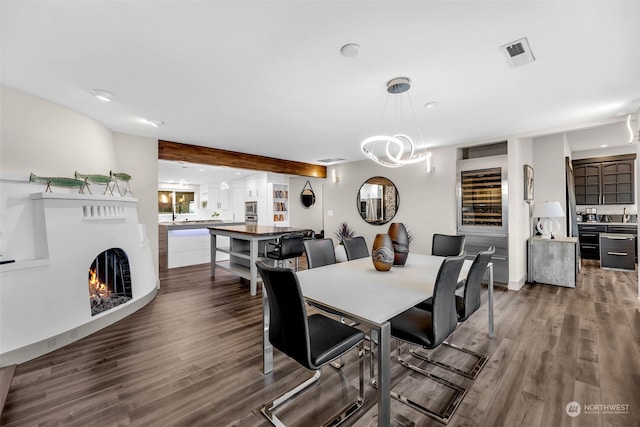 dining space with hardwood / wood-style flooring and beam ceiling