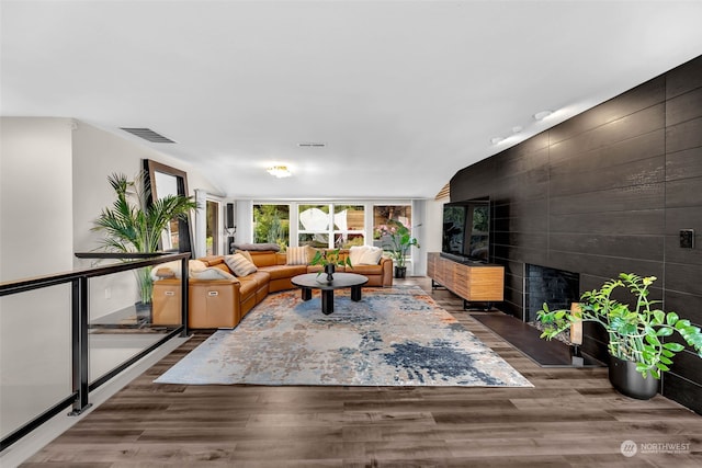 living room with a tile fireplace and hardwood / wood-style flooring