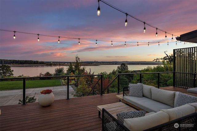 deck at dusk with a water view and an outdoor living space