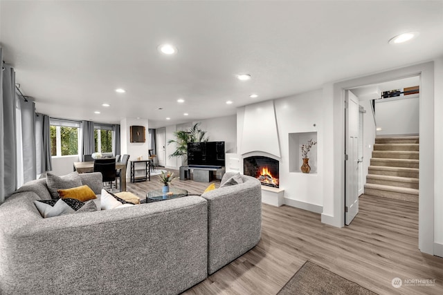 living room featuring light wood-type flooring and a large fireplace