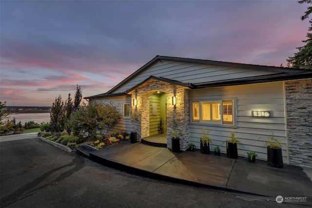 view of front of property featuring central air condition unit and a water view