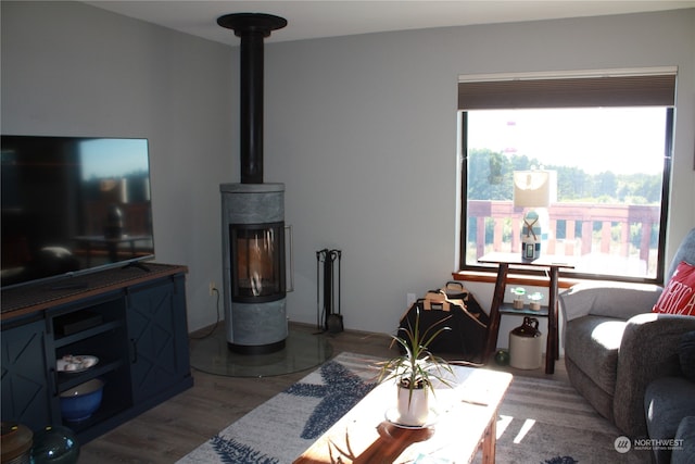 living room featuring plenty of natural light, hardwood / wood-style flooring, and a wood stove