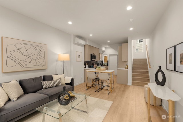 living room with light wood-type flooring and an AC wall unit