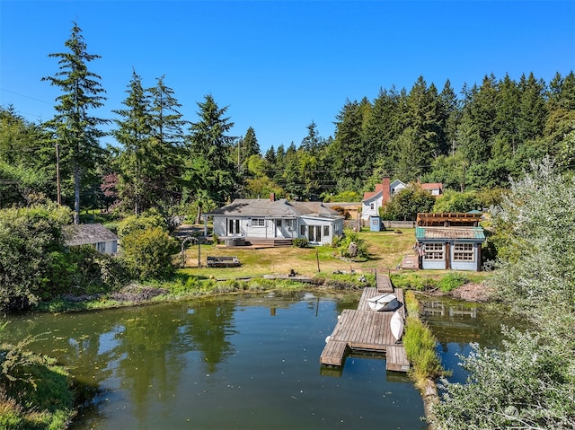 view of dock with a water view and a lawn