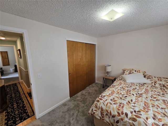 carpeted bedroom featuring a textured ceiling and a closet