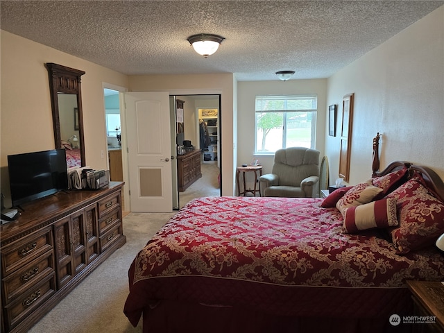 carpeted bedroom featuring a closet and a textured ceiling