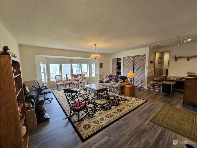 interior space with an inviting chandelier, a textured ceiling, and dark hardwood / wood-style floors