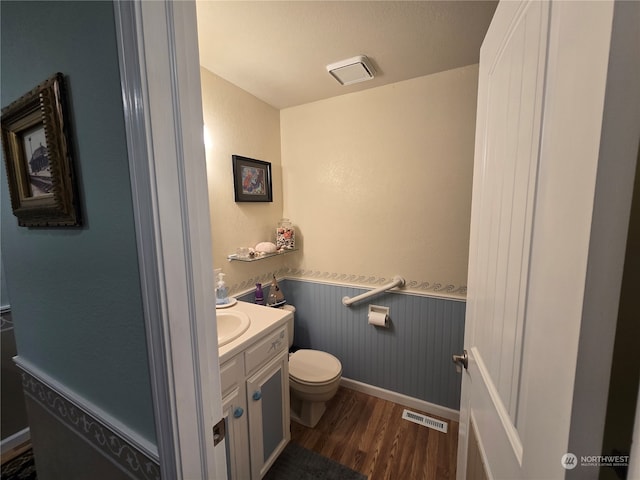 bathroom with a textured ceiling, hardwood / wood-style flooring, vanity, and toilet