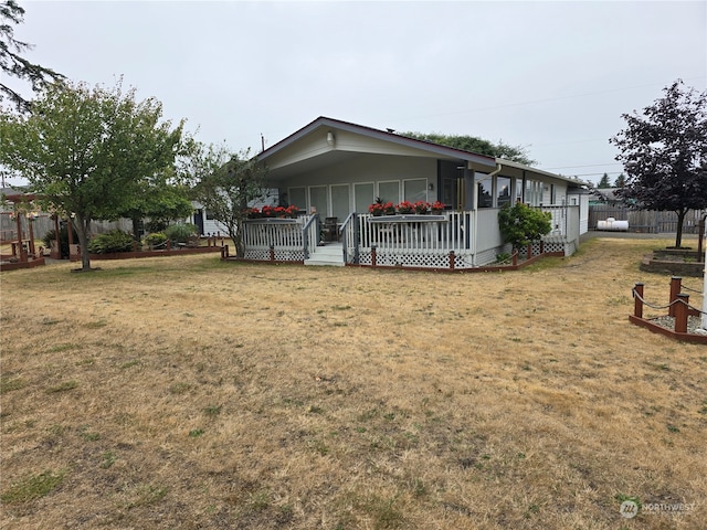 back of house with a lawn and a wooden deck