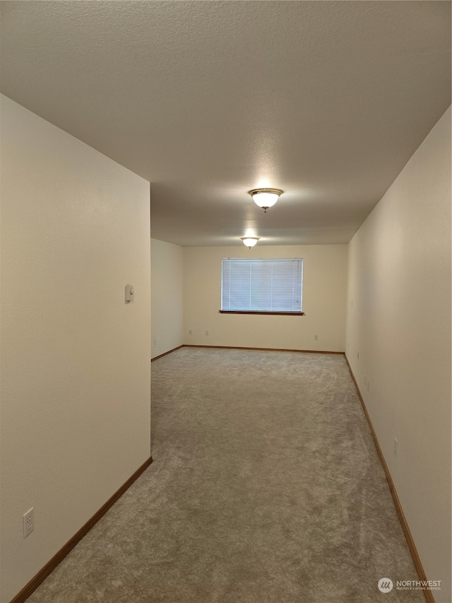 carpeted spare room featuring a textured ceiling