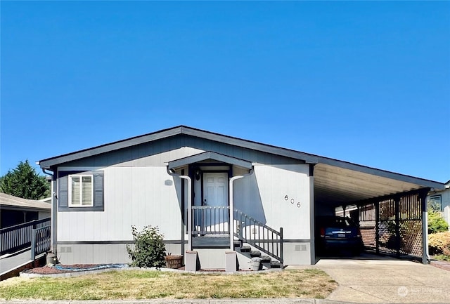 manufactured / mobile home with crawl space, an attached carport, and concrete driveway