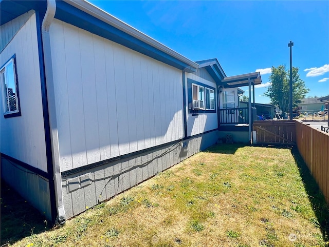 view of side of property with a yard, crawl space, and fence