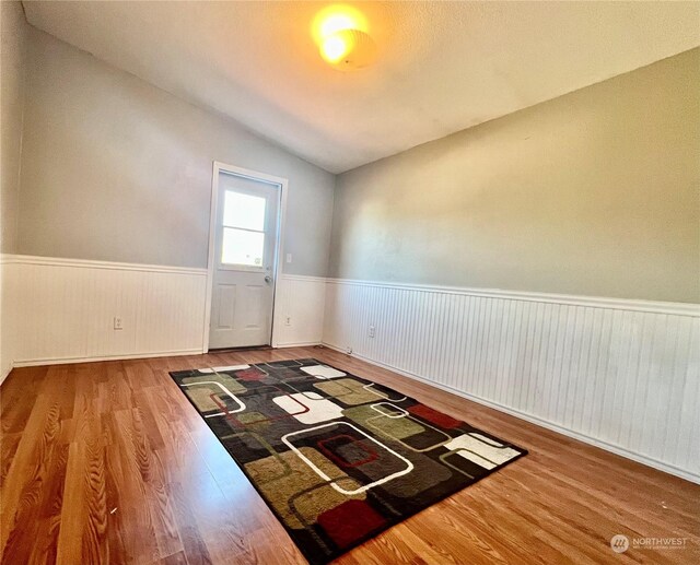 empty room with lofted ceiling and hardwood / wood-style floors