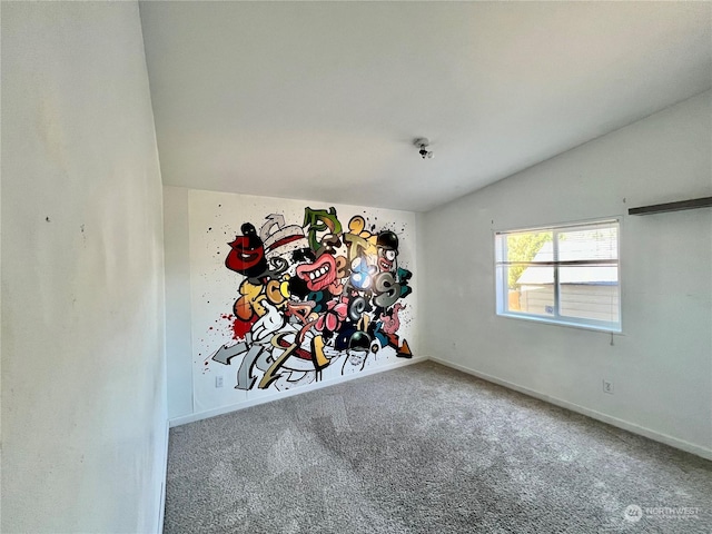 empty room featuring lofted ceiling, carpet flooring, and baseboards