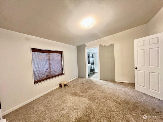 unfurnished room featuring carpet floors and baseboards