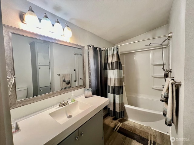 bathroom with a textured wall, toilet, shower / tub combo, vaulted ceiling, and vanity