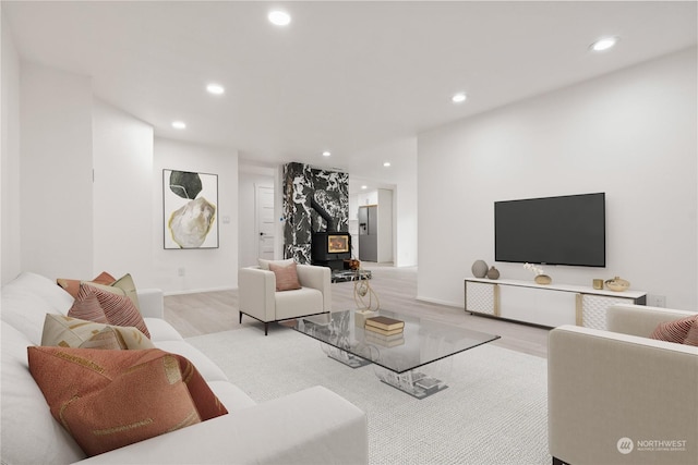 living room with light hardwood / wood-style flooring and a wood stove