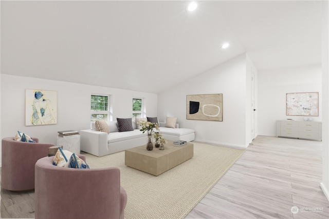 living room featuring lofted ceiling and light hardwood / wood-style floors