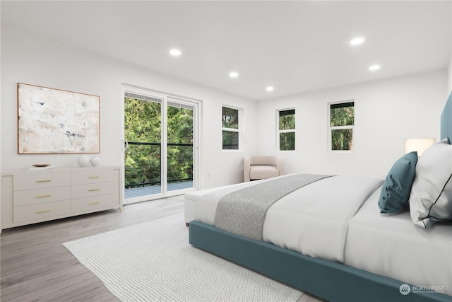 bedroom featuring multiple windows, access to outside, and light wood-type flooring