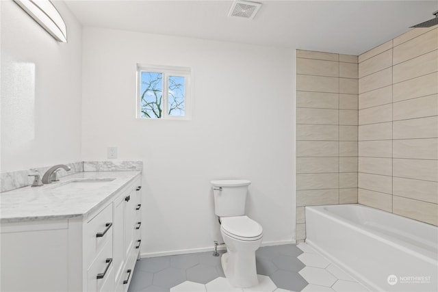 bathroom with tile patterned flooring, vanity, and toilet