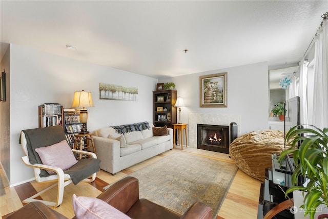 living room featuring a tile fireplace and light wood-type flooring