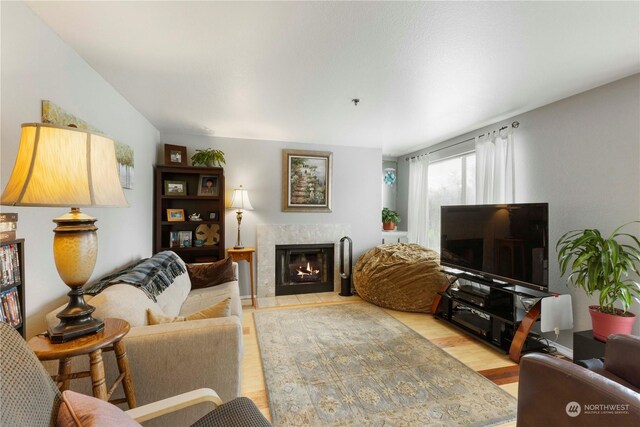 living room featuring a tile fireplace and light hardwood / wood-style floors