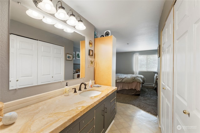 bathroom with tile patterned floors, vanity, and baseboard heating