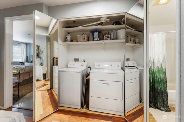 washroom with light hardwood / wood-style floors and washing machine and dryer