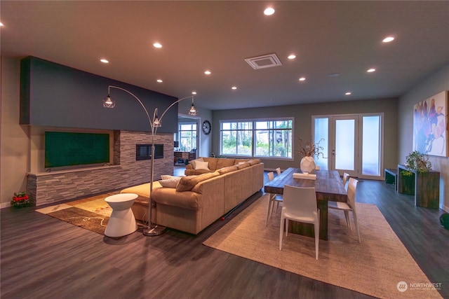 living room featuring a stone fireplace and dark hardwood / wood-style floors