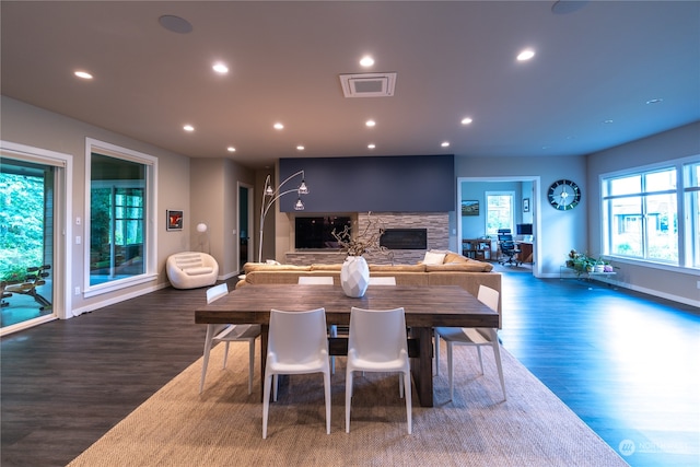 dining space featuring dark wood-type flooring and a fireplace