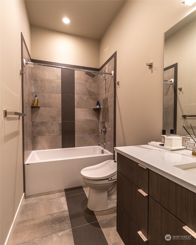 full bathroom featuring tile patterned flooring, toilet, vanity, and tiled shower / bath