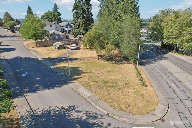 view of road with a residential view and curbs