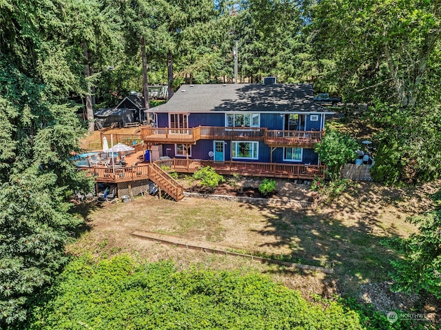 rear view of house with a yard, a deck, and a balcony