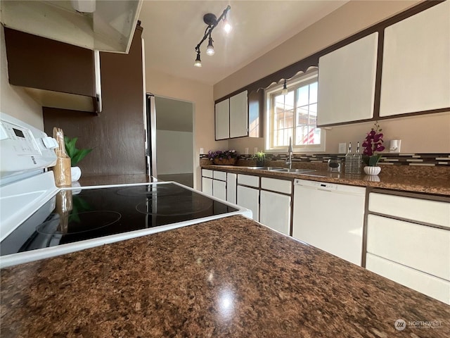 kitchen with sink, white cabinets, dark stone counters, and white dishwasher