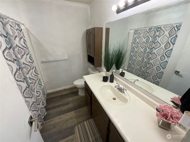 bathroom with toilet, vanity, and hardwood / wood-style flooring