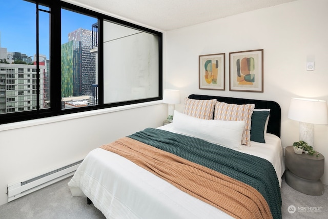 carpeted bedroom featuring a baseboard heating unit