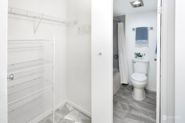 bathroom featuring toilet and tile patterned flooring