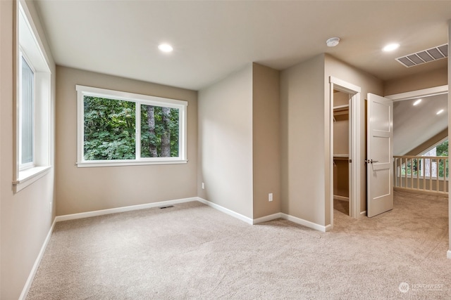 carpeted empty room featuring a wealth of natural light