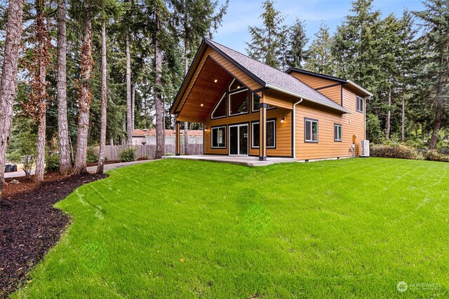 back of property featuring a lawn, fence, cooling unit, a patio, and roof with shingles